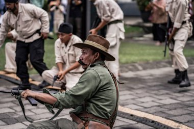 Teatral savaş genel taarruzu, Hollanda sömürge döneminde savaş üniformaları ve silahları kullanılarak gerçekleştirildi. Birbirlerini vuruyorlar. : Yogyakarta, Endonezya - 01 Mart 2022