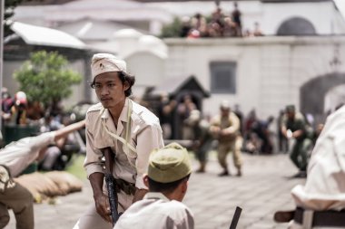 Teatral savaş genel taarruzu, Hollanda sömürge döneminde savaş üniformaları ve silahları kullanılarak gerçekleştirildi. Birbirlerini vuruyorlar. : Yogyakarta, Endonezya - 01 Mart 2022