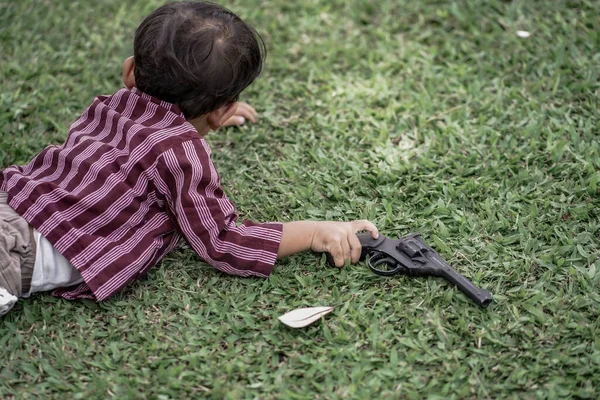 Malý Chlapec Ležící Pistolí — Stock fotografie