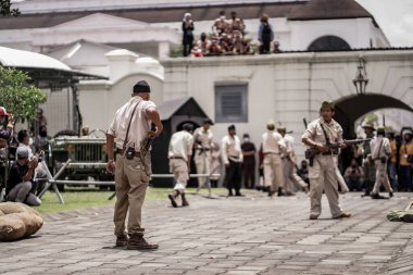 Teatral savaş genel taarruzu, Hollanda sömürge döneminde savaş üniformaları ve silahları kullanılarak gerçekleştirildi. Birbirlerini vuruyorlar. : Yogyakarta, Endonezya - 01 Mart 2022