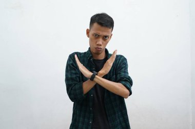 Beyaz arka planda koyu yeşil giyinmiş Asyalı genç avuçlarıyla şarkı söylemeyi kesiyor. Yüzünde olumsuz ve ciddi bir tavır olan bir uyarı ifadesi..