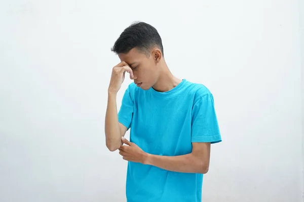 流鼻涕或鼻窦炎的概念 身穿蓝色T恤衫的亚洲男人 手握鼻梁 痛苦不堪 — 图库照片