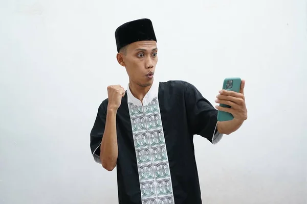 Мусульманский Азиат Выражает Возбужденное Выражение Лица Смотрит Свой Мобильный Телефон — стоковое фото