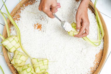 Ketupat yapma süreci bayramda geleneksel bir yemektir. Pirinci ketupat kutusuna koy..
