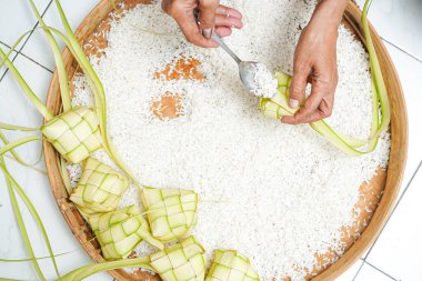 Ketupat yapma süreci bayramda geleneksel bir yemektir. Pirinci ketupat kutusuna koy..