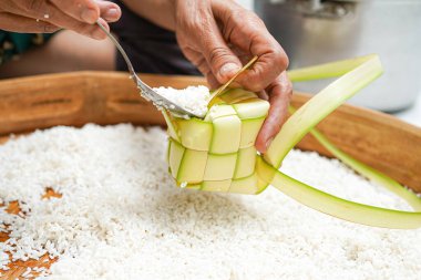 Ketupat yapma süreci bayramda geleneksel bir yemektir. Pirinci ketupat kutusuna koy..