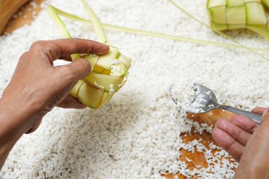 Ketupat yapma süreci bayramda geleneksel bir yemektir. Pirinci ketupat kutusuna koy..