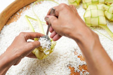 Ketupat yapma süreci bayramda geleneksel bir yemektir. Pirinci ketupat kutusuna koy..