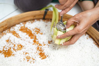 Ketupat yapma süreci bayramda geleneksel bir yemektir. Pirinci ketupat kutusuna koy..