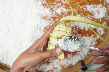 Ketupat yapma süreci bayramda geleneksel bir yemektir. Pirinci ketupat kutusuna koy..