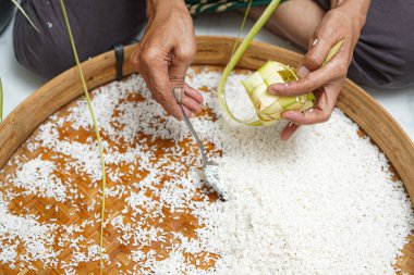 Ketupat yapma süreci bayramda geleneksel bir yemektir. Pirinci ketupat kutusuna koy..