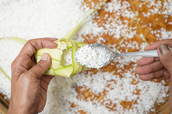 Ketupat yapma süreci bayramda geleneksel bir yemektir. Pirinci ketupat kutusuna koy..