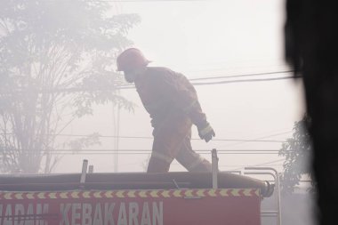 İtfaiyeciler beklemede ve mobilya deposundaki yangını söndürmeye çalışıyorlar. : Yogyakarta, Endonezya - 12 Mayıs 2022