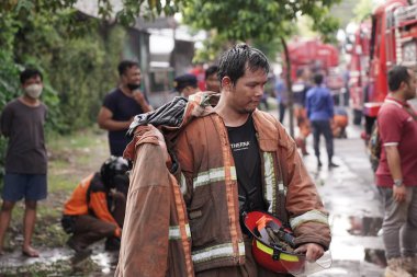 firefighters who are on standby and trying to extinguish the fire at the furniture warehouse fire site. : Yogyakarta, Indonesia - 12 May 2022