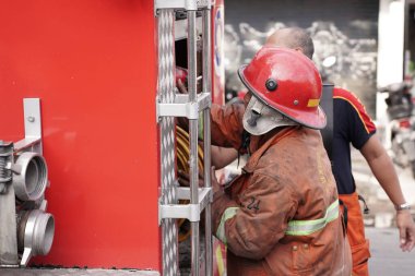 İtfaiyeciler beklemede kalıp mobilya deposundaki yangını söndürmeye çalışıyorlar. : Yogyakarta, Endonezya - 12 Mayıs 2022