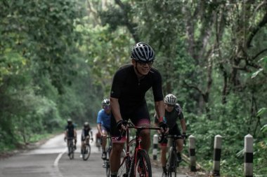 Yokuş yukarı giden yolda bisiklet sürücülerinin ifadesi ve stili, Ambarrukmo 2022 Tur için test rotasına hazırlanıyor.: Sleman, Endonezya - 21 Mayıs 2022