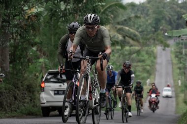 Yokuş yukarı giden yolda bisiklet sürücülerinin ifadesi ve stili, Ambarrukmo 2022 Tur için test rotasına hazırlanıyor.: Sleman, Endonezya - 21 Mayıs 2022