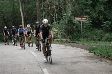 İfade ve profesyonel yol bisikletçileri yokuş aşağı giden yolda, Ambarrukmo 2022 'nin test rotasına hazırlanıyorlar.: Sleman, Endonezya - 21 Mayıs 2022