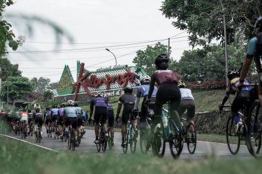 Hızlı giden bir grup bisikletçi ikonik Kulon progo sınırını geçti ve Ambarrukmo 2022 için bir test rotası hazırladı.: Sleman, Endonezya - 21 Mayıs 2022