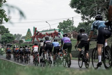 Hızlı giden bir grup bisikletçi ikonik Kulon progo sınırını geçti ve Ambarrukmo 2022 için bir test rotası hazırladı.: Sleman, Endonezya - 21 Mayıs 2022