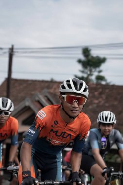 Yokuş yukarı giderken bisiklet sürücülerinin stili ve ifadesi, Ambarrukmo 2022 'nin test rotası için hazırlanıyor.: Sleman, Endonezya - 21 Mayıs 2022