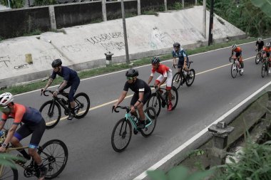 Yokuş yukarı giden yolda bisiklet sürücülerinin ifadesi ve stili, Ambarrukmo 2022 Tur için test rotasına hazırlanıyor.: Sleman, Endonezya - 21 Mayıs 2022