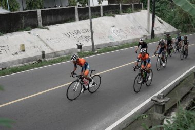 Yokuş yukarı giden yolda bisiklet sürücülerinin ifadesi ve stili, Ambarrukmo 2022 Tur için test rotasına hazırlanıyor.: Sleman, Endonezya - 21 Mayıs 2022