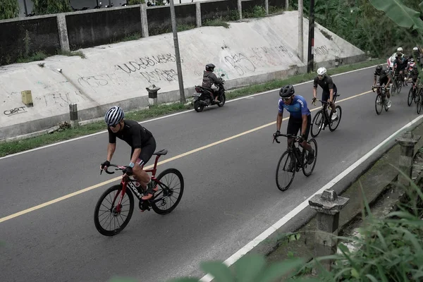 Yokuş yukarı giden yolda bisiklet sürücülerinin ifadesi ve stili, Ambarrukmo 2022 Tur için test rotasına hazırlanıyor.: Sleman, Endonezya - 21 Mayıs 2022