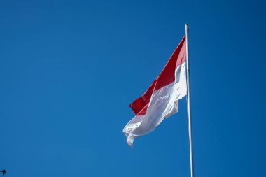 Mavi gökyüzü arkaplanlı Endonezya bayrağı.