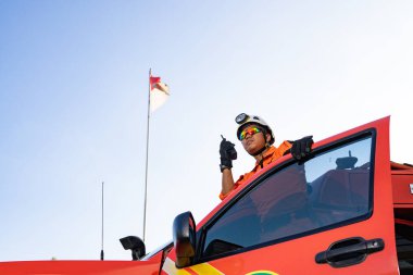 Bir Basarna kurtarma ekibi arabanın kapısında nöbet tutuyor ve Handy Talky 'i taşıyor. : Yogayakarta, Endonezya - 13 Mayıs 2022