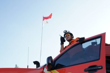 Bir Basarna kurtarma ekibi arabanın kapısında nöbet tutuyor ve Handy Talky 'i taşıyor. : Yogayakarta, Endonezya - 13 Mayıs 2022