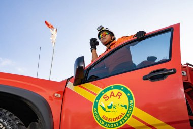 Bir Basarna kurtarma ekibi arabanın kapısında nöbet tutuyor ve Handy Talky 'i taşıyor. : Yogayakarta, Endonezya - 13 Mayıs 2022