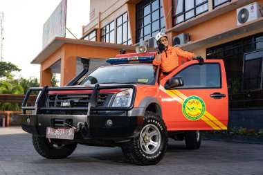 Bir Basarna kurtarma ekibi arabanın kapısında nöbet tutuyor ve Handy Talky 'i taşıyor. : Yogayakarta, Endonezya - 13 Mayıs 2022
