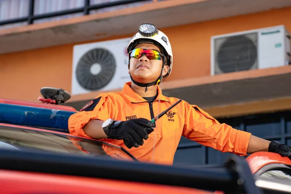 Bir Basarna kurtarma ekibi arabanın kapısında nöbet tutuyor ve Handy Talky 'i taşıyor. : Yogayakarta, Endonezya - 13 Mayıs 2022