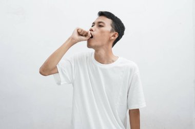 Asyalı adam uykulu esneme, ayakta uyuma, beyaz arka planda yarım vücut portresi.