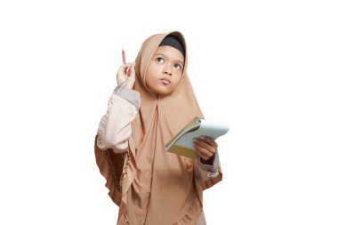 beautiful girl wearing a brown hijab Muslim dress, is thinking about something before writing in her notebook. isolated on a white background