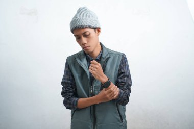 Asian young man wearing navy blue vest and beanie wearing smartwatch, isolated on white background cool style like top model.