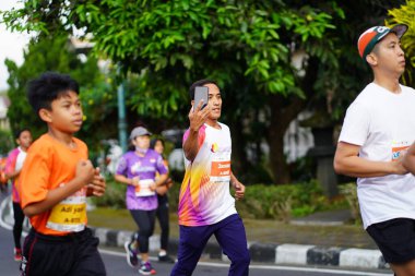 Magelang Endonezya 'da maraton yarışı, insanlar 5-10 kilometre uzaklıktaki şehir yollarına ayak bastı. Yarışmalar düzenlemek ve eğlenmek. : MAGELANG, Endonezya - 18 Eylül 2022.