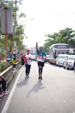 Magelang Endonezya 'da maraton yarışı, insanlar 5-10 kilometre uzaklıktaki şehir yollarına ayak bastı. Yarışmalar düzenlemek ve eğlenmek. : MAGELANG, Endonezya - 18 Eylül 2022.