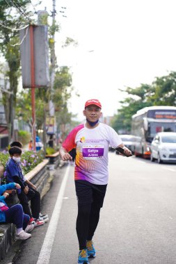 Magelang Endonezya 'da maraton yarışı, insanlar 5-10 kilometre uzaklıktaki şehir yollarına ayak bastı. Yarışmalar düzenlemek ve eğlenmek. : MAGELANG, Endonezya - 18 Eylül 2022.