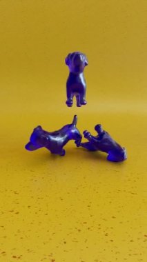 Komik jelibon köpekleri sarı arka plana düşer. Hareket tasarımı 3d canlandırma