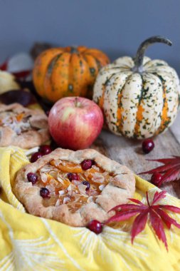 Balkabaklı börekler, kırmızı akçaağaç yaprakları ve masa üzerindeki dekoratif kabak. Sonbahar yemeği. Mevsimlik sebzeler ve balkabağı turtasıyla. 