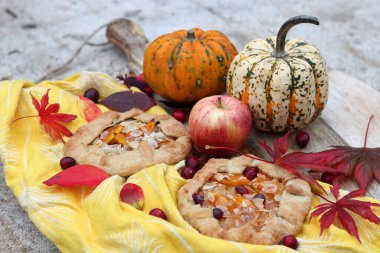 Balkabaklı börekler, kırmızı akçaağaç yaprakları ve masa üzerindeki dekoratif kabak. Sonbahar yemeği. Mevsimlik sebzeler ve balkabağı turtasıyla. 