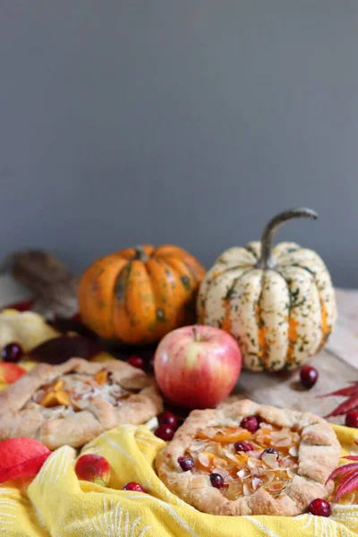 Balkabaklı börekler, kırmızı akçaağaç yaprakları ve masa üzerindeki dekoratif kabak. Sonbahar yemeği. Mevsimlik sebzeler ve balkabağı turtasıyla. 