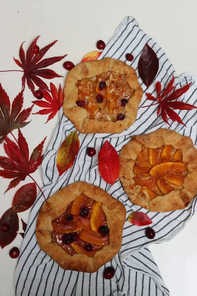 Masasında kırmızı sonbahar yaprakları olan balkabağı galetleri. Beyaz arka plan. Sonbahar sezonunun makbuzları. Sağlıklı beslenme konsepti. Şükran Günü menüsü fikirleri. Organik sebzeler.. 