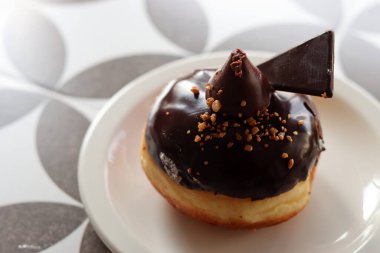 Traditional Israeli doughnut on a white plate. Chocolate doughnut close up photo. Authentic sweets of Middle East. 