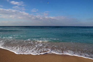 Açık mavi deniz suyu. Fotoğrafı kapat. Sakin deniz, mavi gökyüzü, sakin manzara. Kumsalda sıcak bir gün.. 