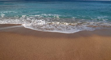 Açık mavi deniz suyu. Fotoğrafı kapat. Sakin deniz, mavi gökyüzü, sakin manzara. Kumsalda sıcak bir gün.. 