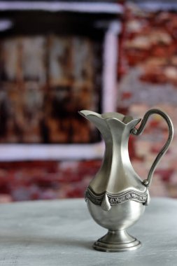 Hâlâ gümüş sürahi ile yaşıyorum. Retro nesnenin fotoğrafını kapat. Kopyalama alanı olan desenli arkaplan. 