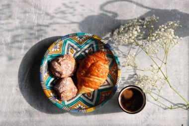 Seramik tabakta kruvasan. Pasta parçalarının fotoğrafını kapat. Tatlı yemek. Hayat fotoğrafı..  